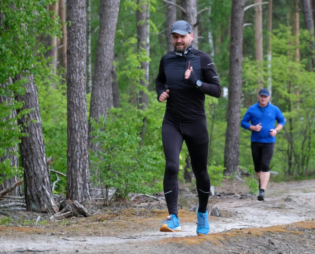 Athletes jogging along a forest trail, representing the topic of testosterone cypionate vs enanthate and workout recovery.