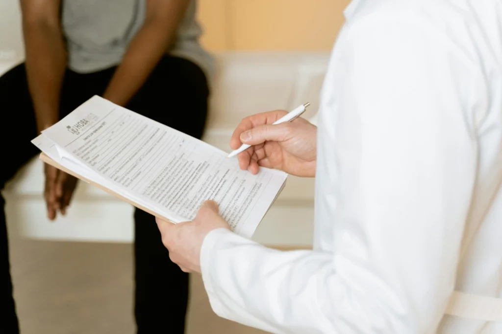 Doctor reviewing patient intake forms during a consultation about signs of low testosterone and hormone health concerns.