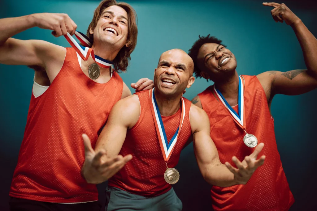 Group of male athletes showing off their medals, used for content about testosterone cypionate vs enanthate and muscle recovery.