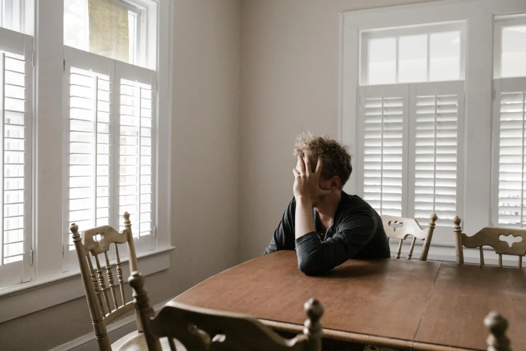 Individual sitting in silence with signs of stress and fatigue, often associated with symptoms of low testosterone in men.