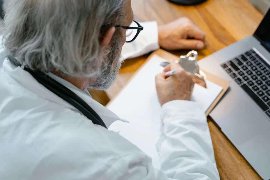 Medical professional working at a laptop for a comparison guide on the cheapest online TRT clinic services.