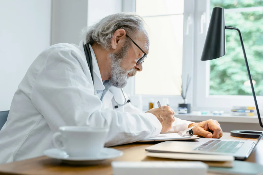 Doctor writing notes during a patient consultation about testosterone replacement therapy fertility and how hormone treatment may affect reproductive health.