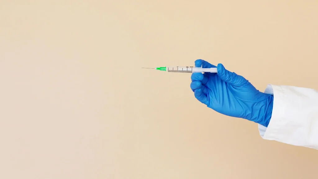 Healthcare professional holding a syringe during a demonstration about the best place to inject TRT safely and properly.