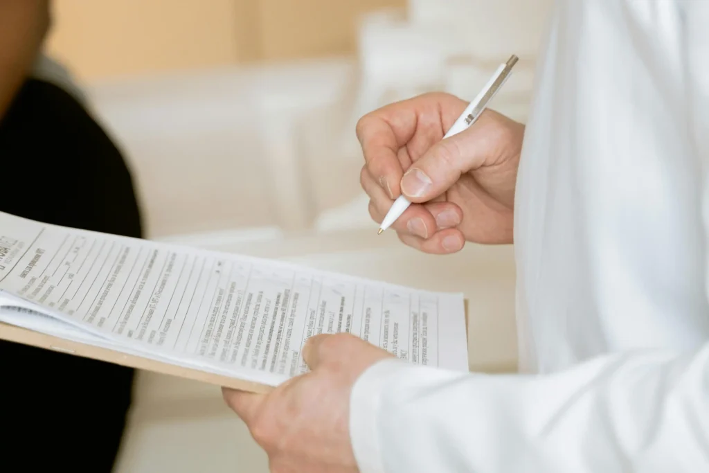 Healthcare professional reviewing patient paperwork during a consultation about enclomiphene vs TRT treatment options.
