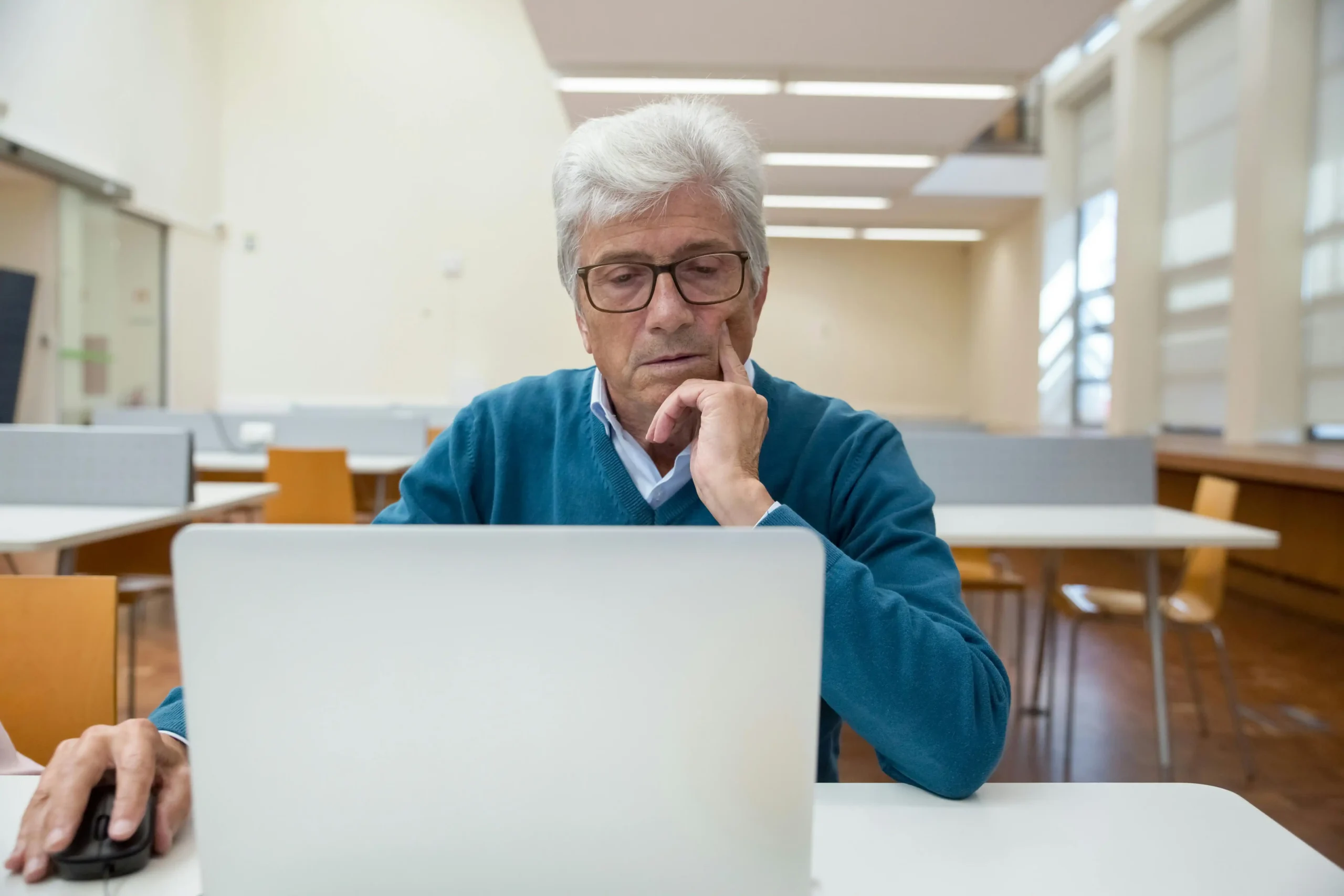 Man at a desk doing his research on online TRT clinic options on a laptop while researching TRT Nation vs Fountain TRT.