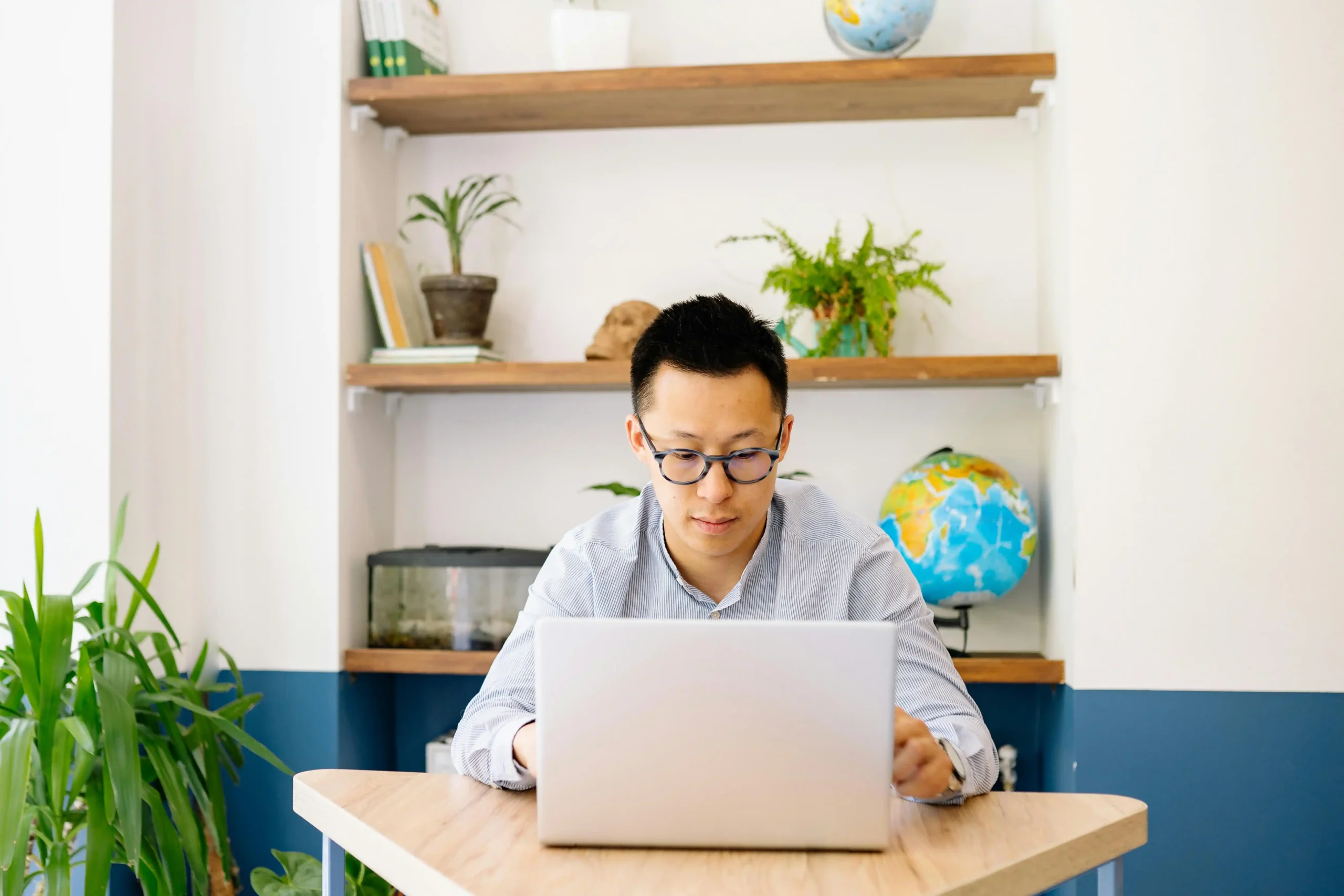 Man at home desk reading TRT nation reviews on his laptop while evaluating online TRT clinic pricing and process.