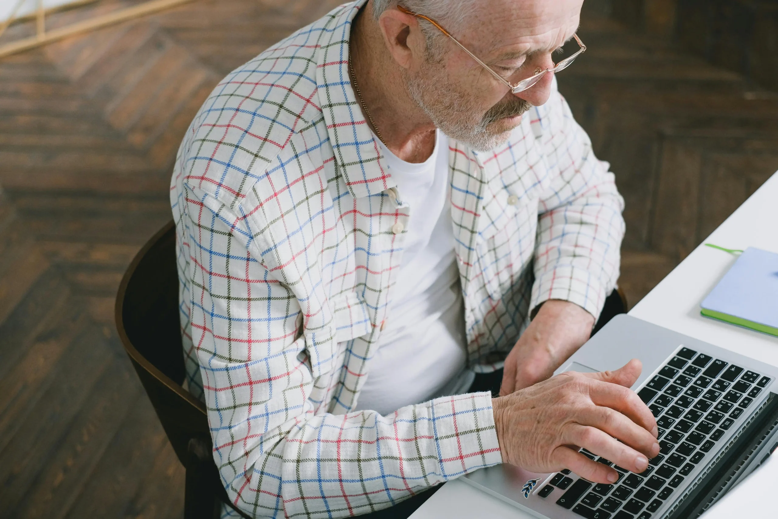 Man in a kitchen reading information on his laptop, considering how TRT and fertility decisions could affect his family planning.