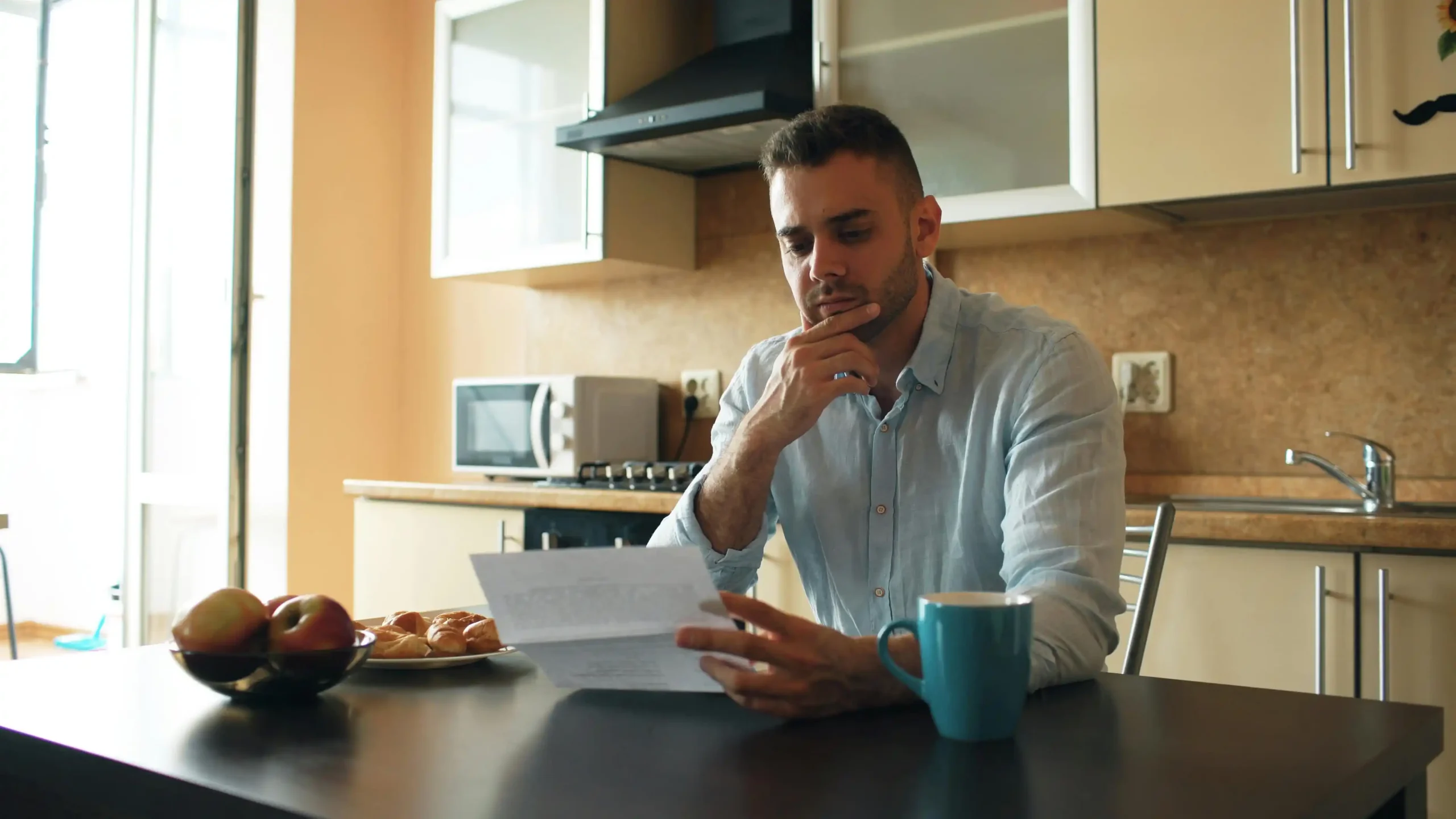 Man in his late thirties reviewing lab results at a kitchen table, illustrating the decision between enclomiphene vs TRT for low testosterone treatment.
