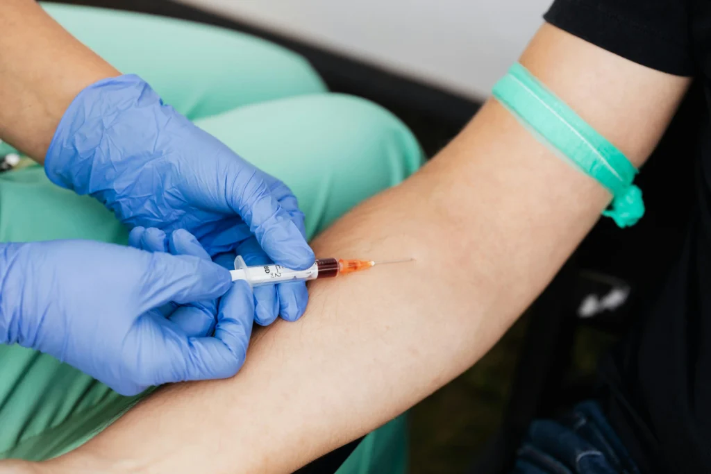 Medical professional preparing an injection in a patient’s arm while explaining the best place to inject TRT for safe administration.
