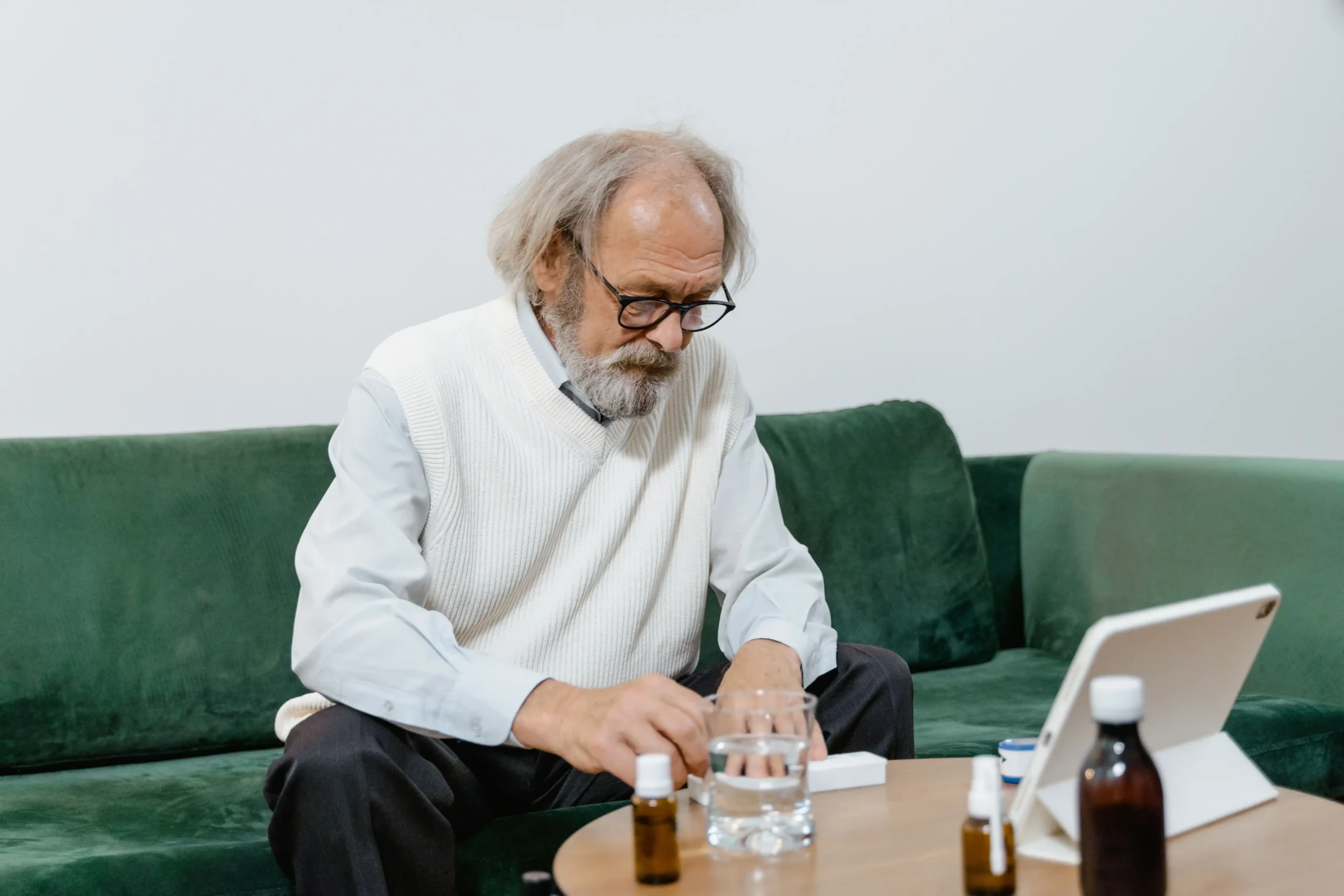 Man at home reviewing online ED treatment options on a laptop, comparing telehealth services for erectile dysfunction in 2026.