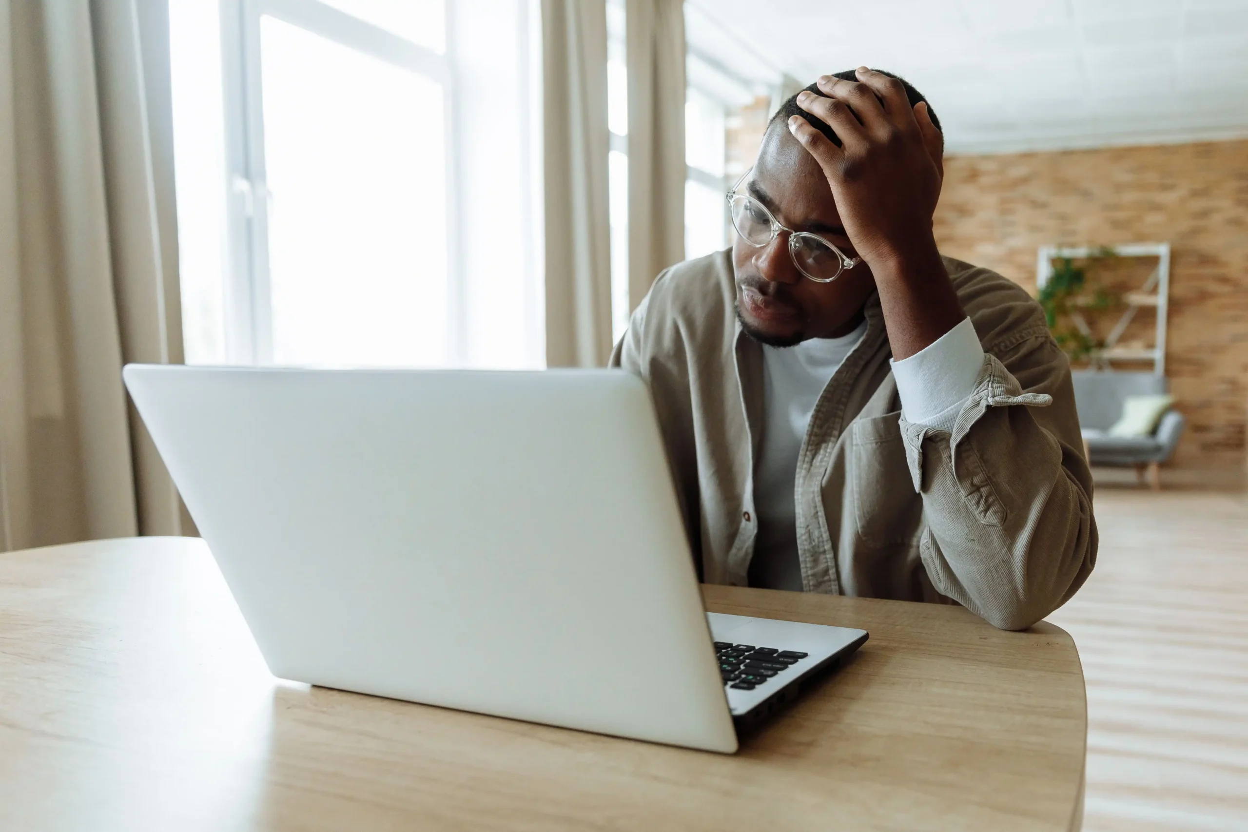 Man comparing online men's health telehealth options on a laptop while researching treatments.