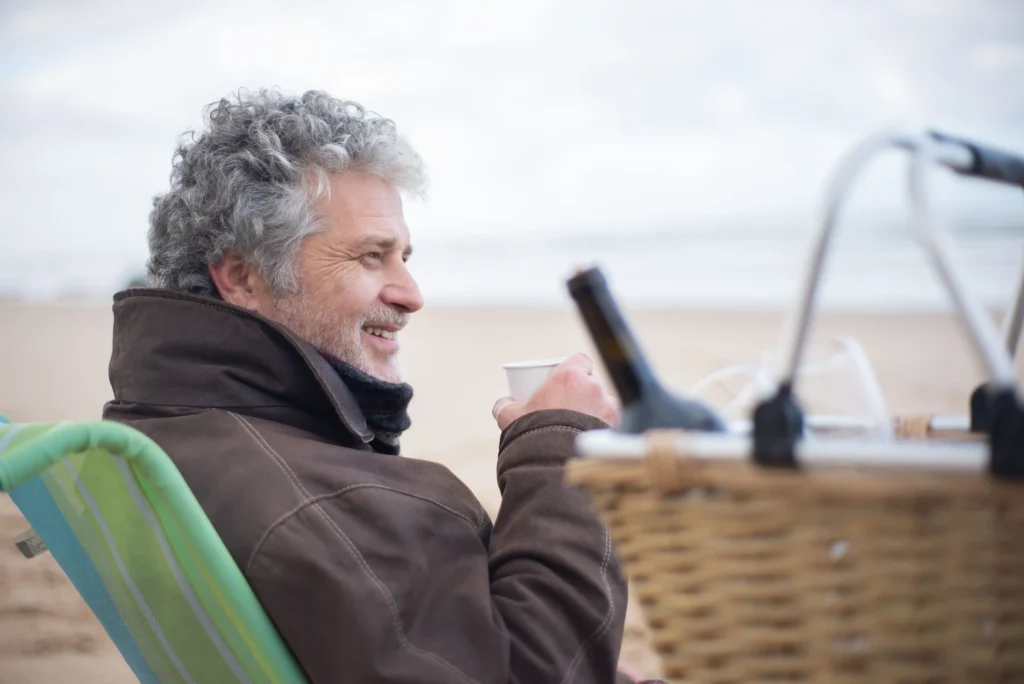 Older man smiling while enjoying time outdoors, highlighting awareness of low testosterone symptoms men over 40 such as low energy and decreased stamina.