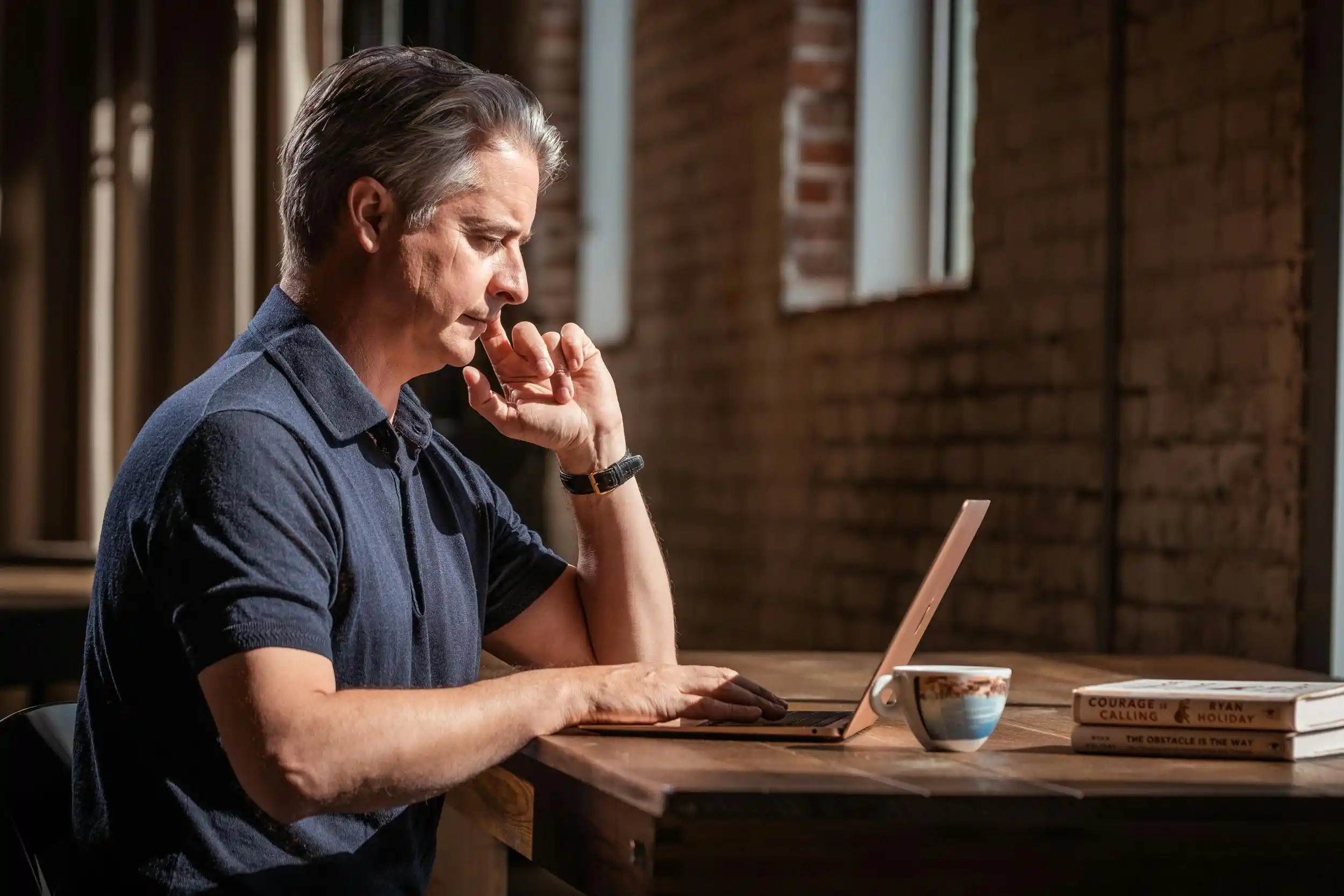 Man reviewing online TRT provider options on a laptop, weighing Hone Health vs TRT Nation for 2026.