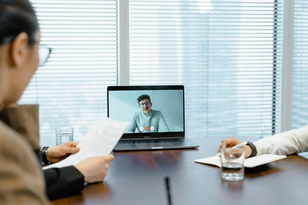 Professionals reviewing documents during a virtual healthcare consultation on a laptop, highlighting the convenience of telemedicine and remote patient support in the context of Marek Health vs Defy Medical.