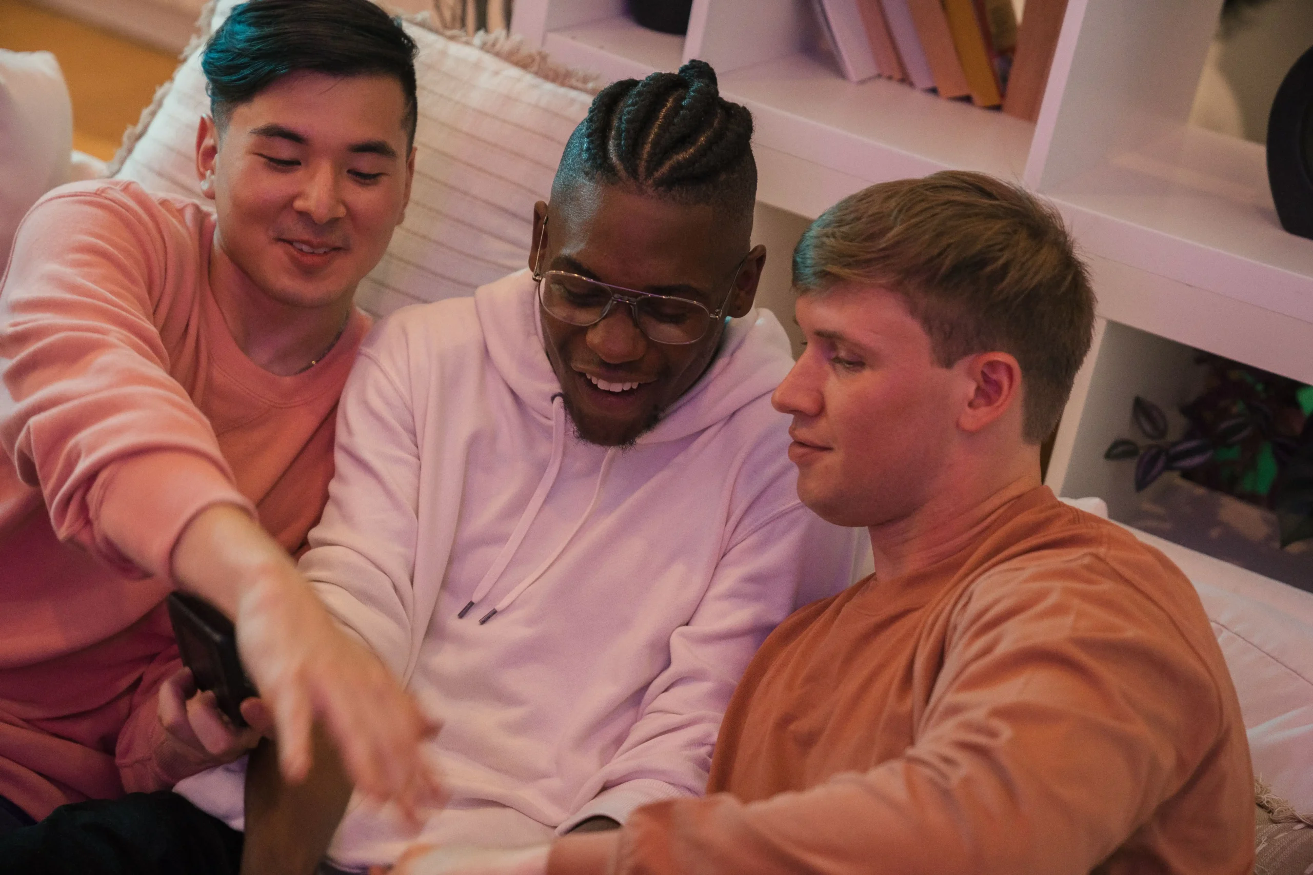 Three friends relaxing on a sofa while looking at a smartphone together, sharing opinions and experiences that reflect authentic Ro reviews and customer feedback.