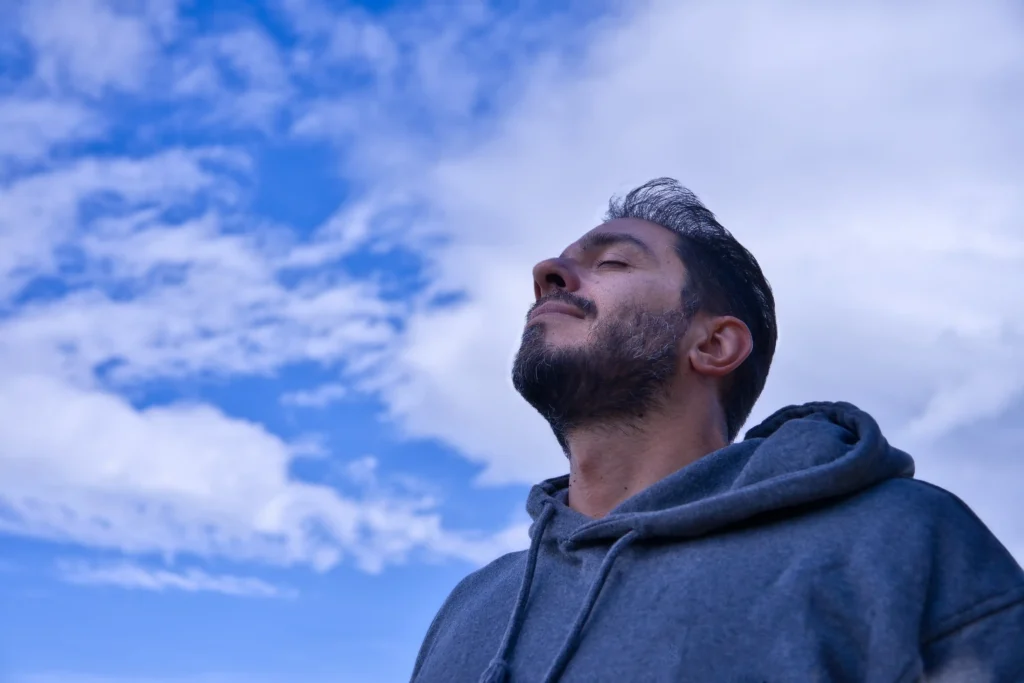 Adult breathing fresh air outdoors against blue
