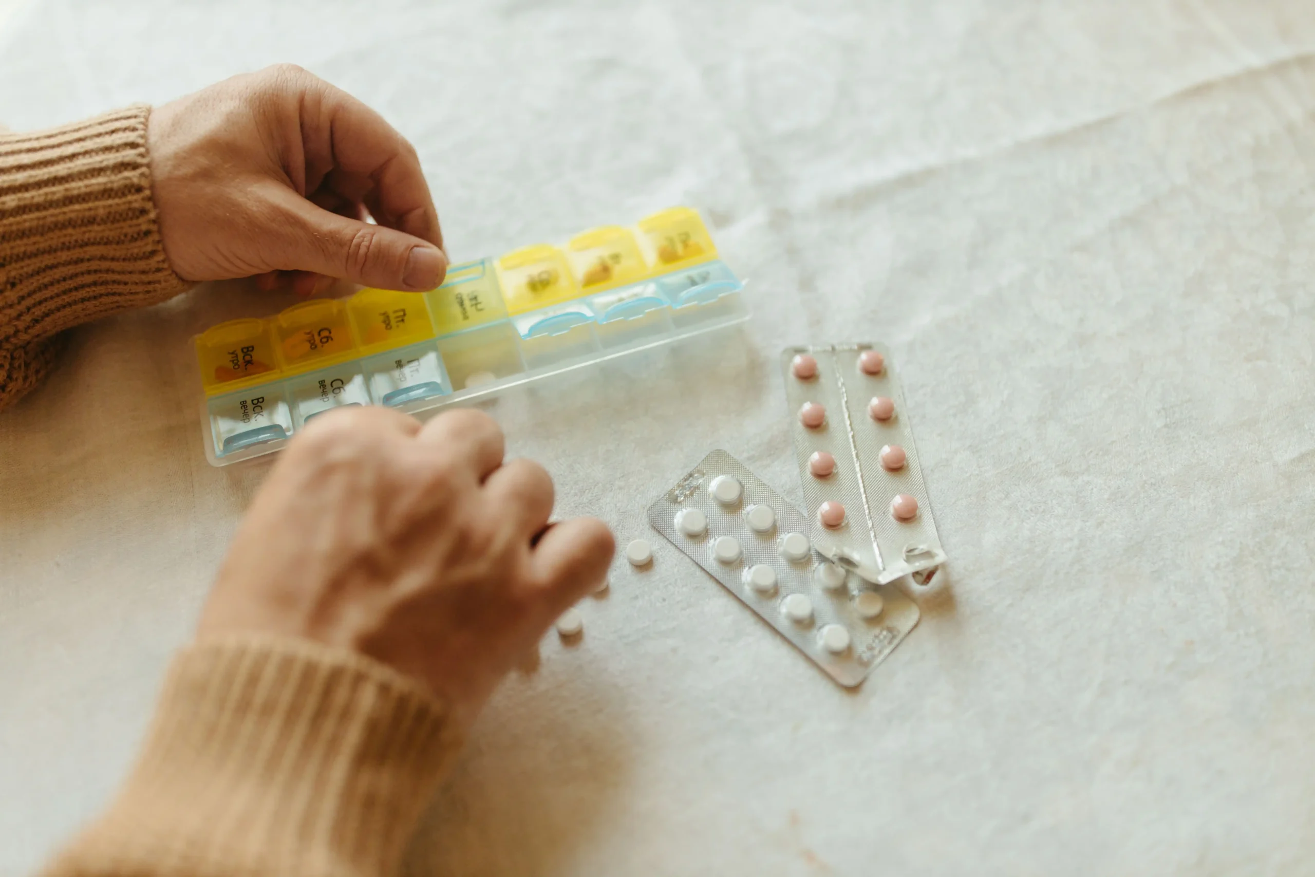 Person preparing daily pills and supplements while looking for the best testosterone booster.