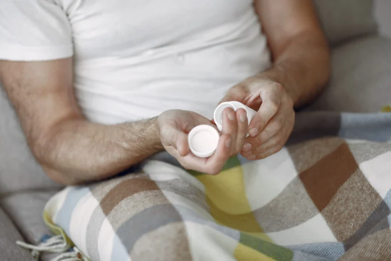 Close-up of a man holding a small medication bottle after reading a BlueChew review.