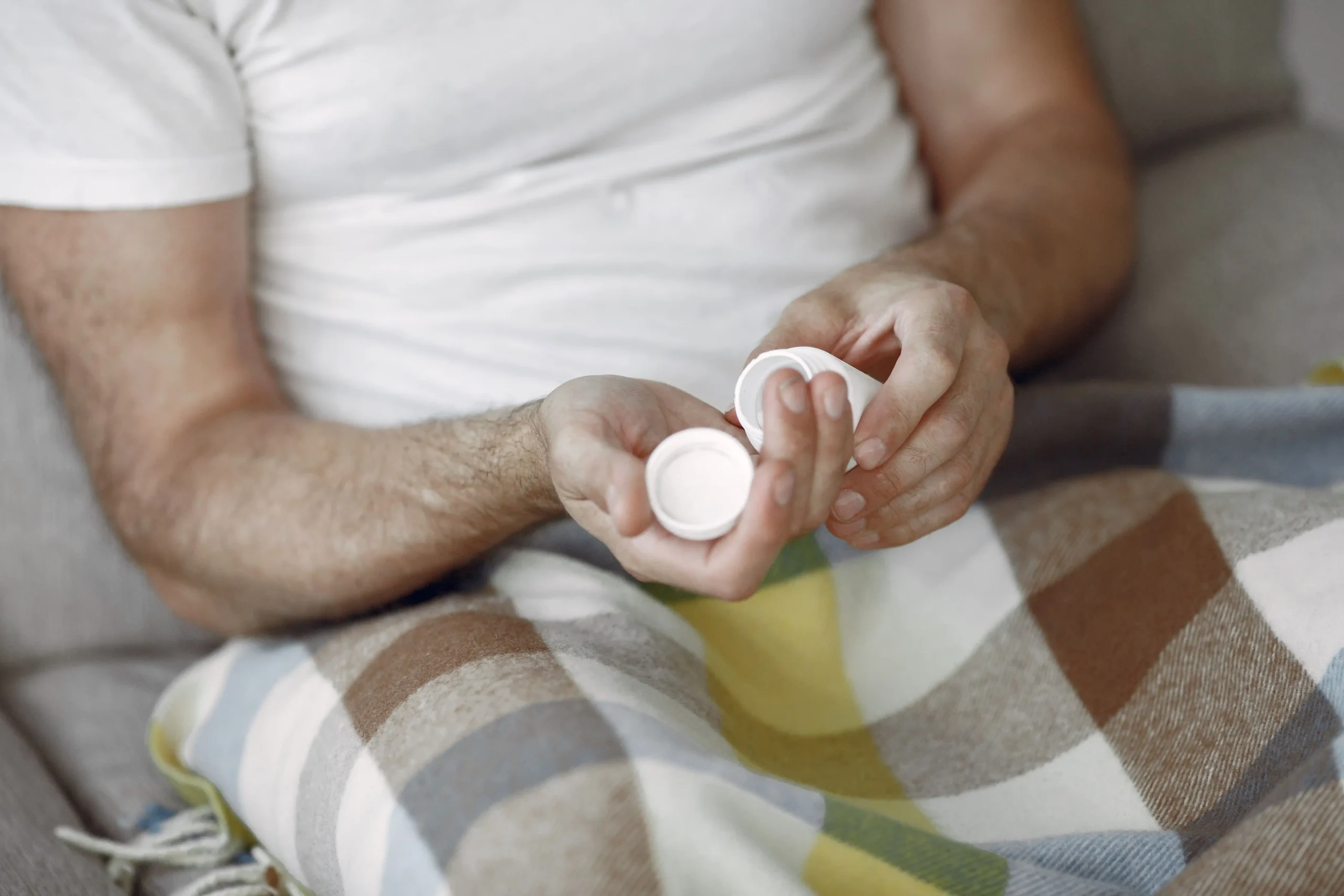Close-up of a man holding a small medication bottle after reading a BlueChew review.