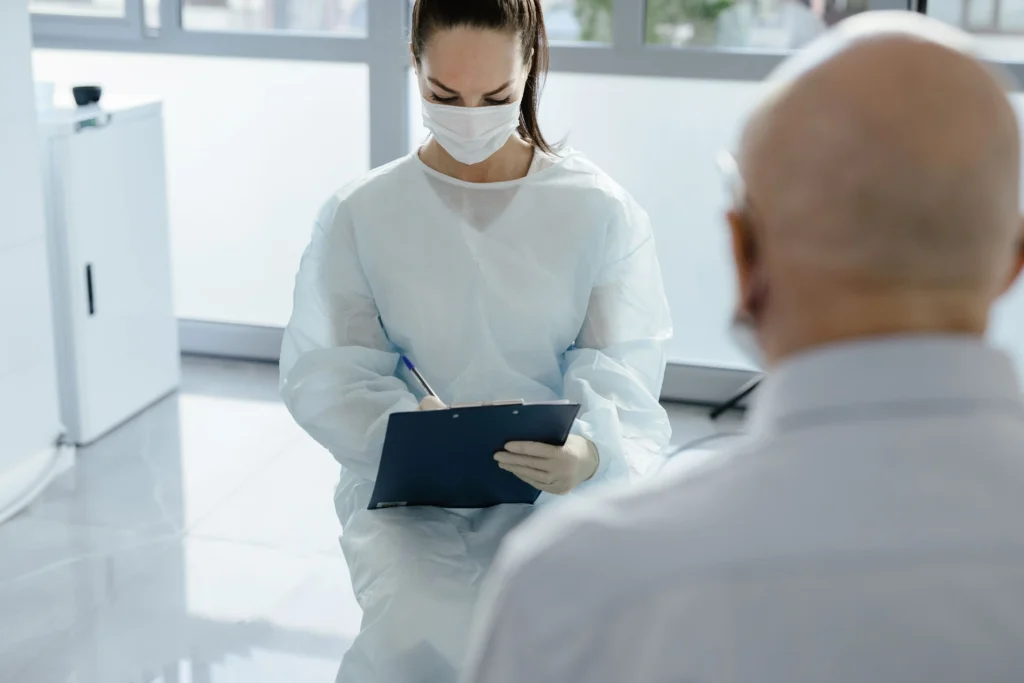 Healthcare professional taking notes during a consultation about ED treatment options.