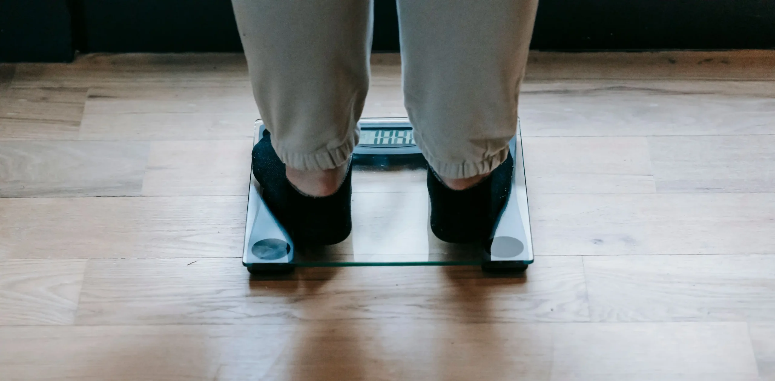 Person standing on a digital weighing scale, representing weight management and treatment options in a Henry Meds vs Ro comparison.
