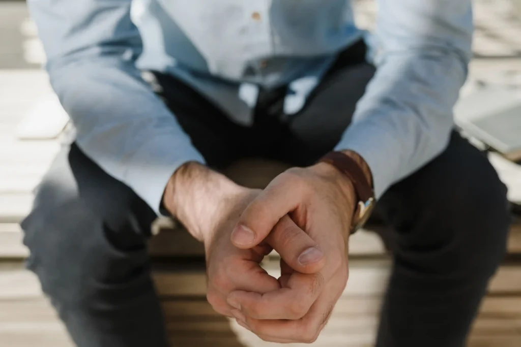 Man sitting thoughtfully with his hands together while considering how long does TRT take to work.