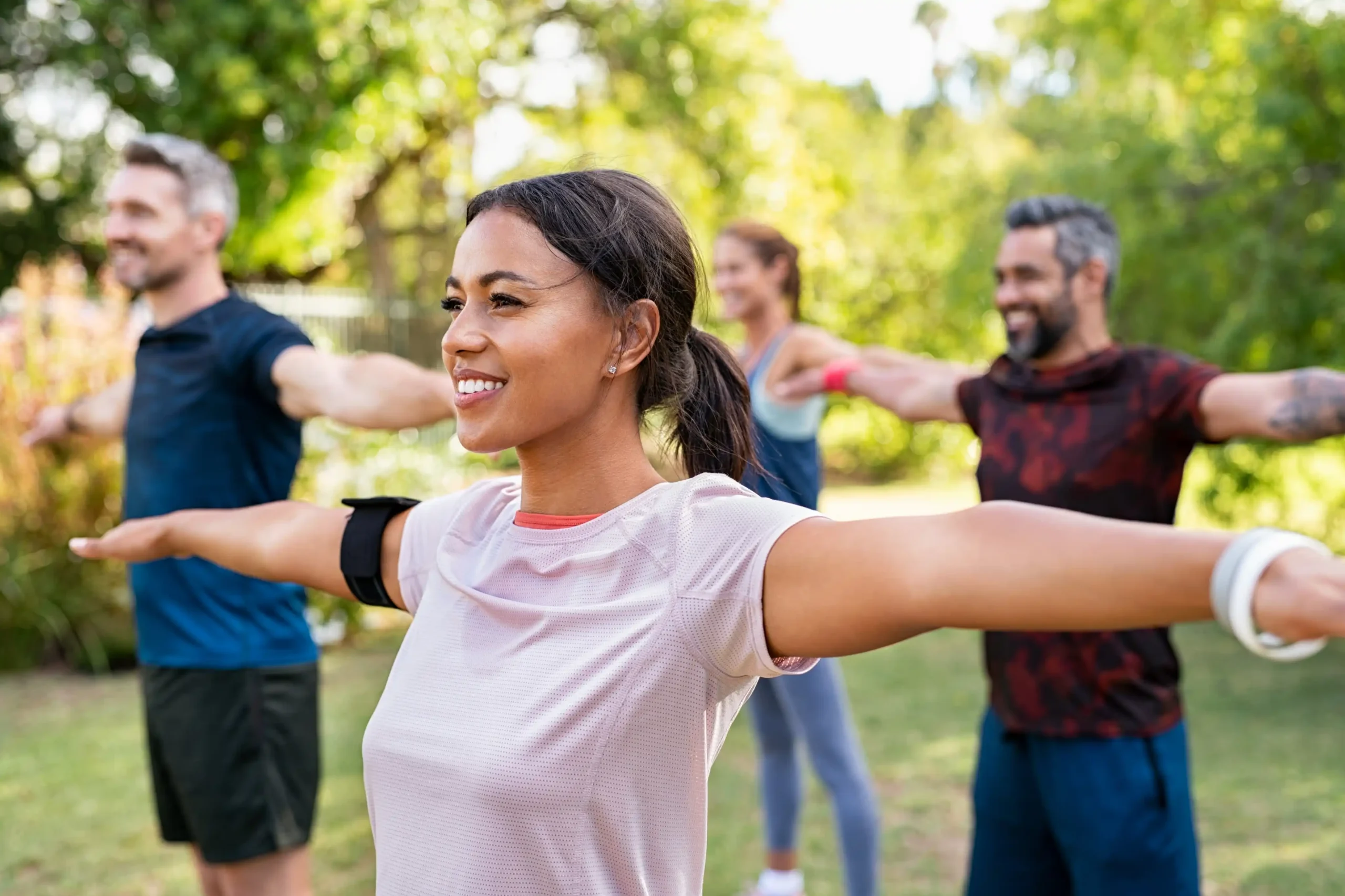 A woman exercising outdoors in a park with a friend