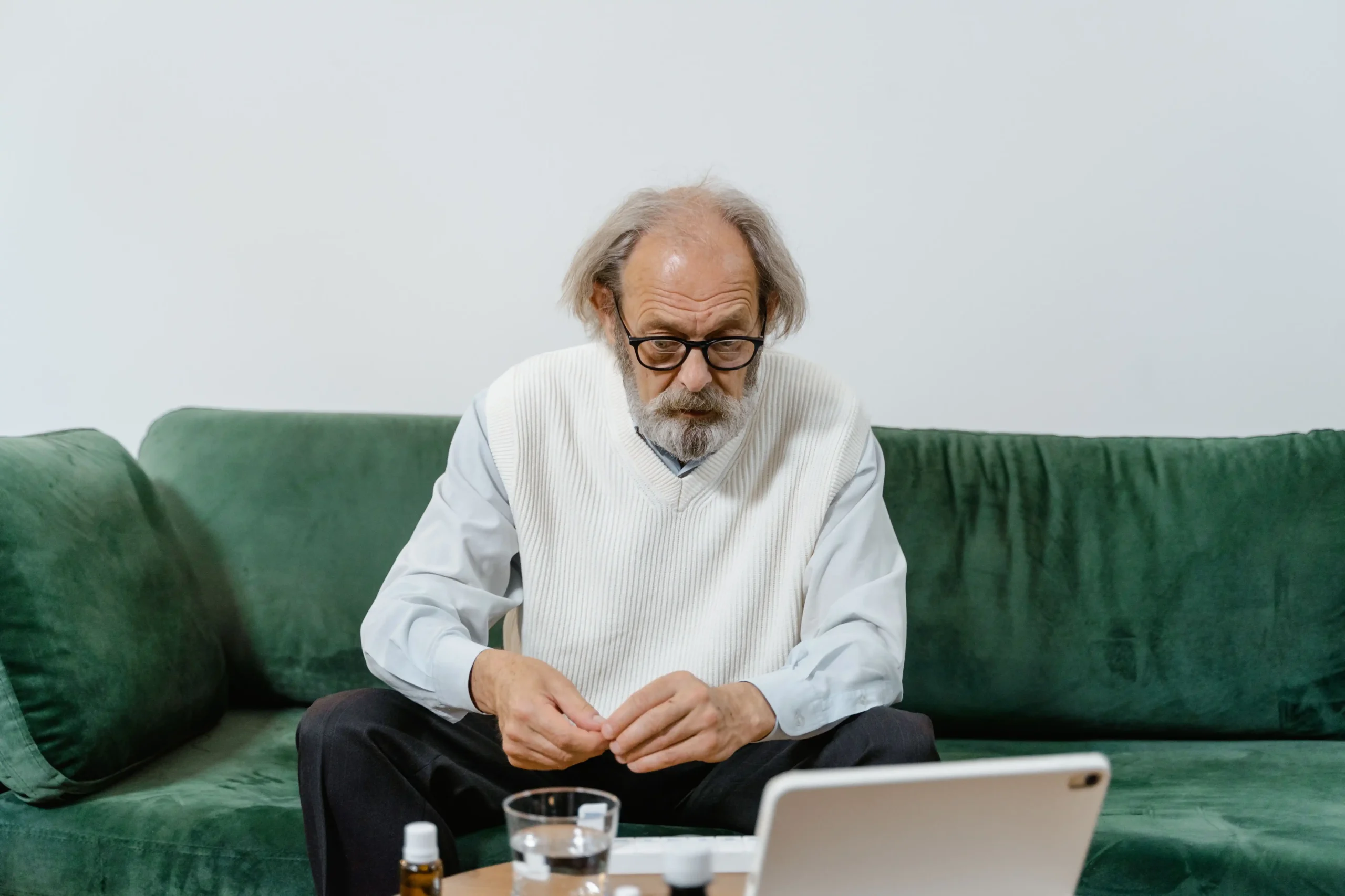 Older man researching testosterone declines with age on a laptop at home.