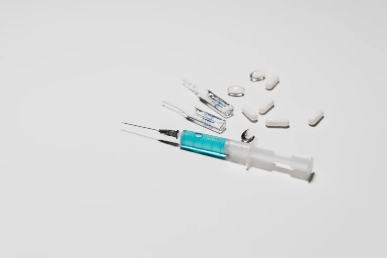 Medical syringe and medication vials representing testosterone injections vs gel treatment options.