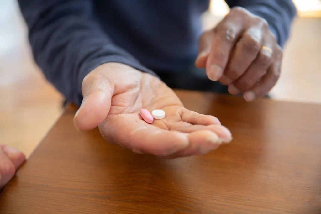 Man taking supplements as he considers whether do testosterone boosters work.