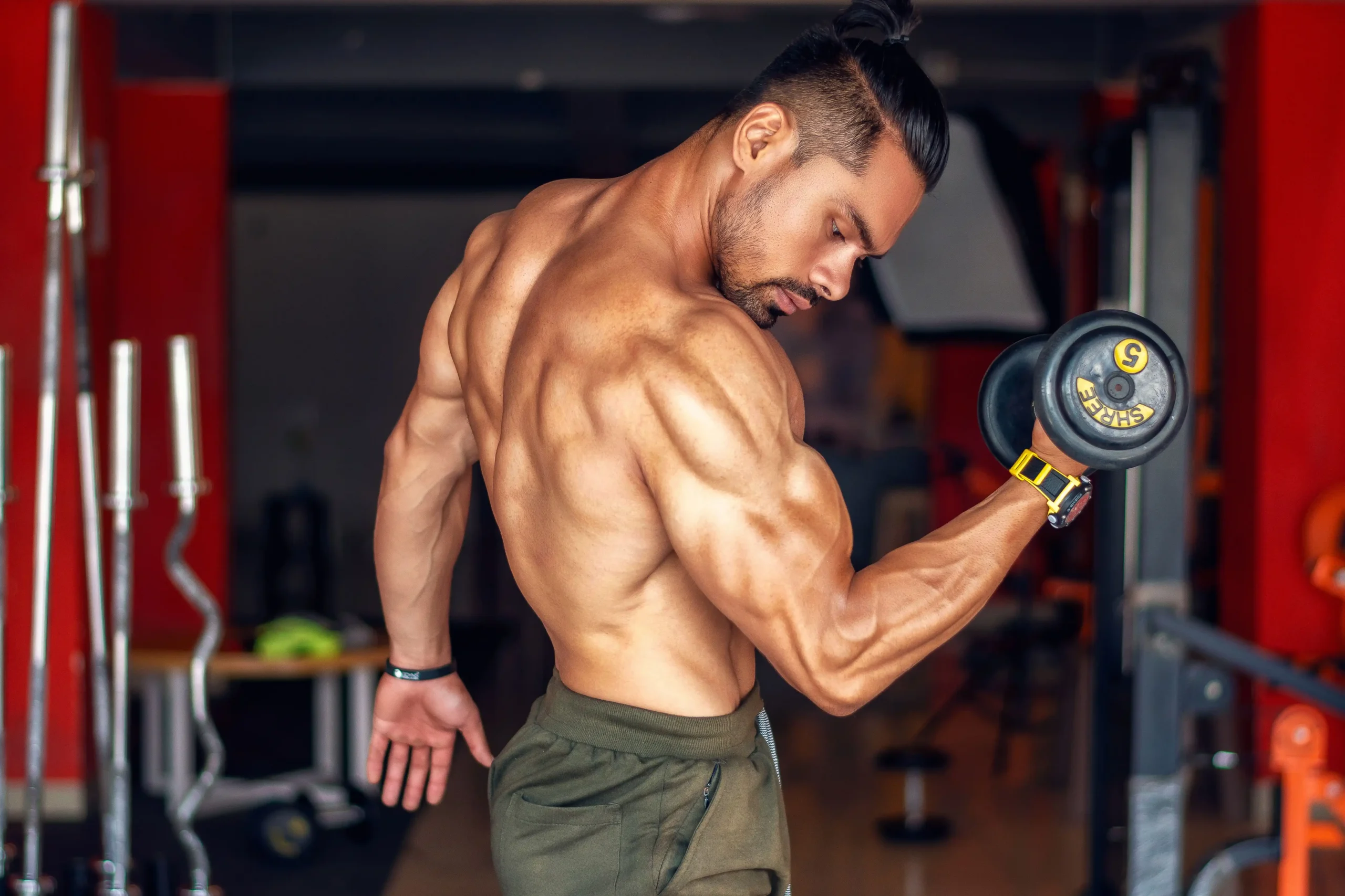 Man lifting weights while considering testosterone booster vs TRT.
